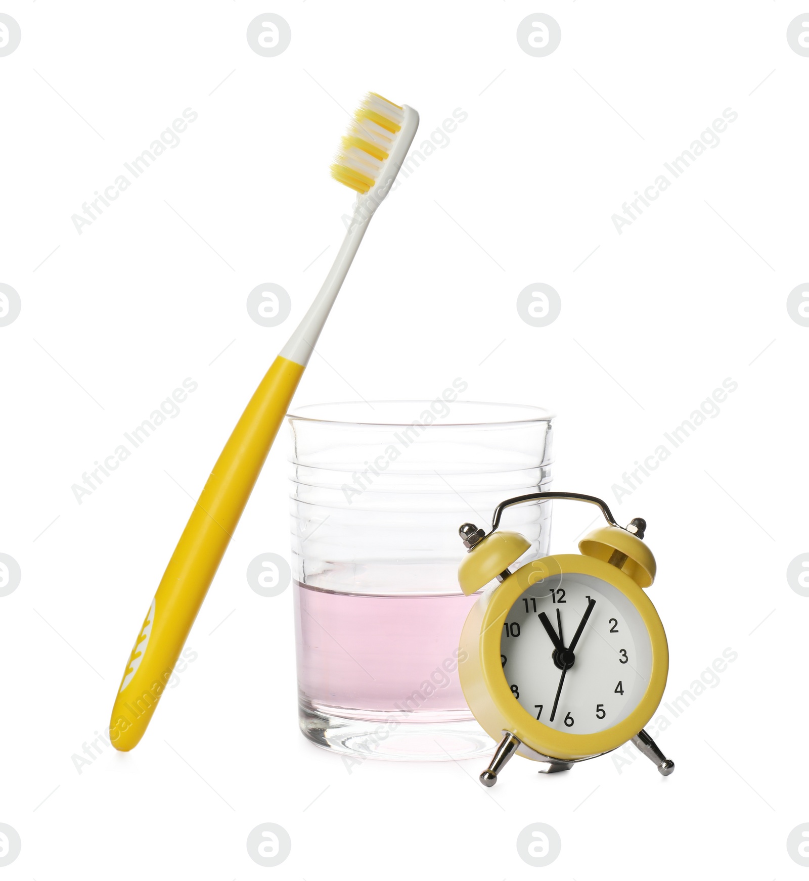 Photo of Mouthwash, toothbrush and alarm clock on white background