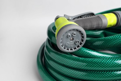 Photo of Watering hose with sprinkler on light grey background, closeup. Space for text