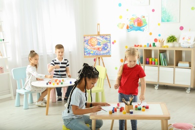 Photo of Cute little children painting at lesson indoors