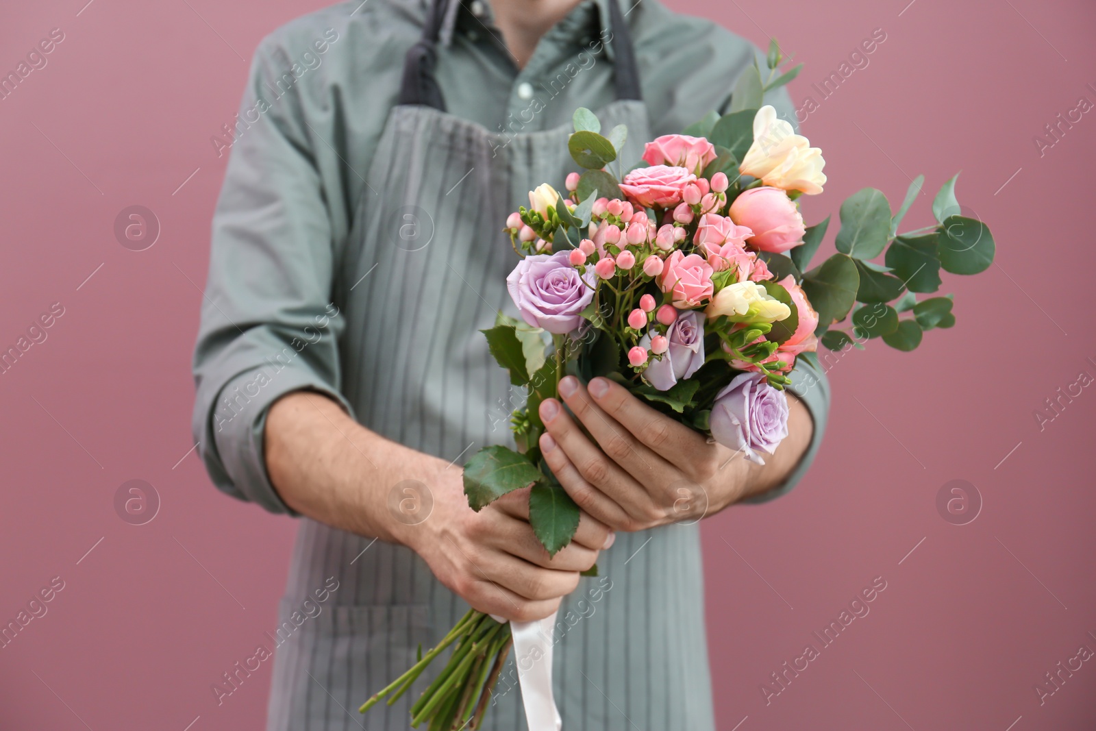 Photo of Male florist with beautiful bouquet on color background