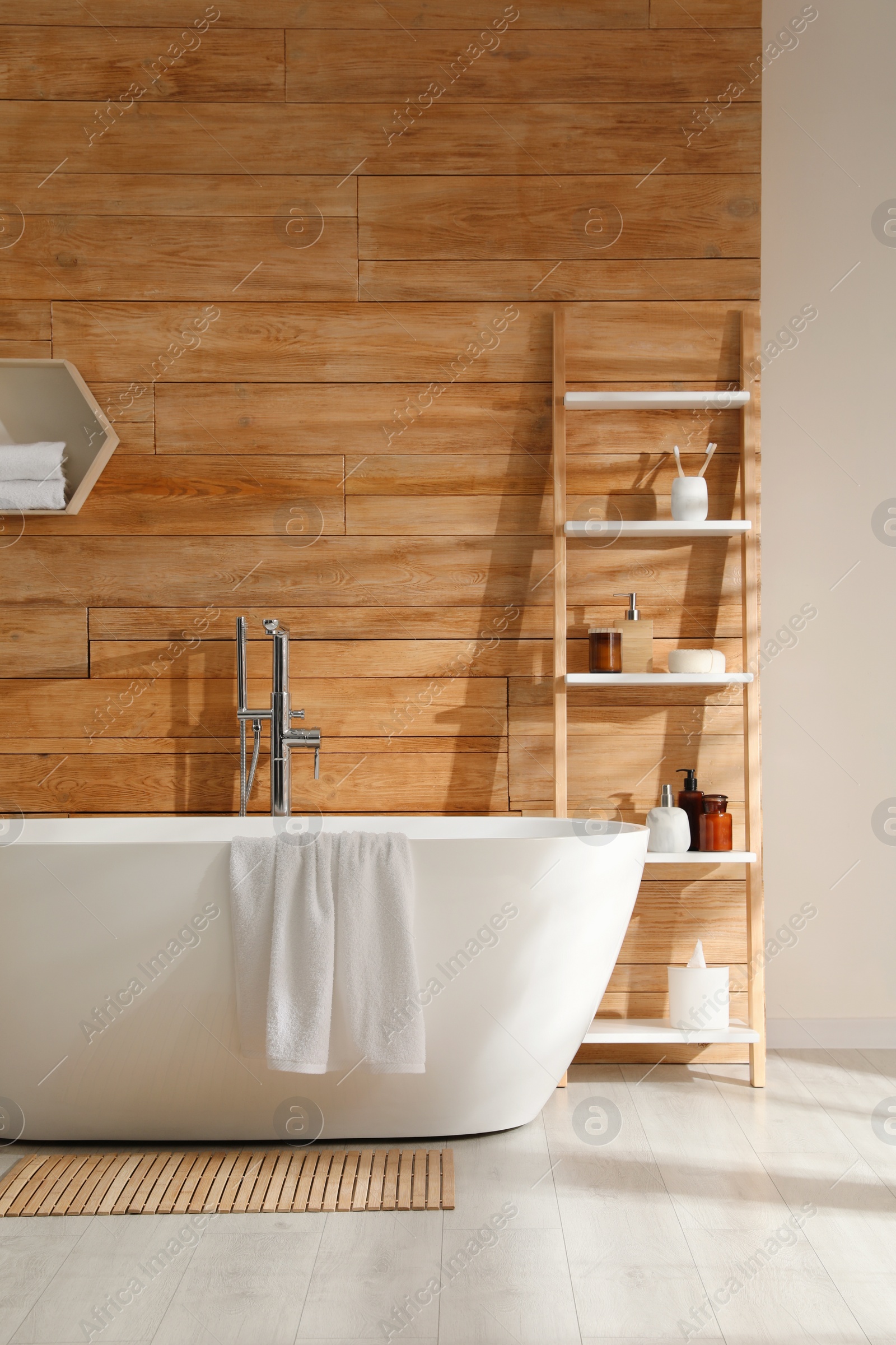 Photo of Bathroom interior with white tub and decor near wooden wall