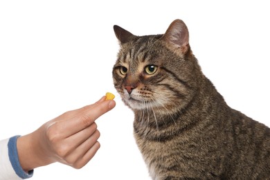 Photo of Woman giving heart shaped pill to cute cat on white background. Vitamins for animal