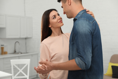 Happy couple dancing in kitchen at home