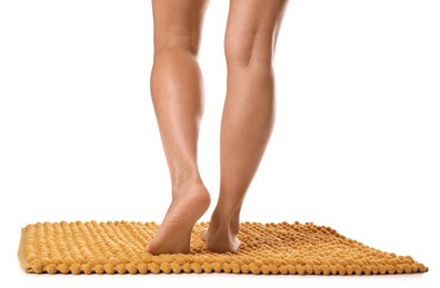 Photo of Woman standing on soft orange bath mat against white background, closeup