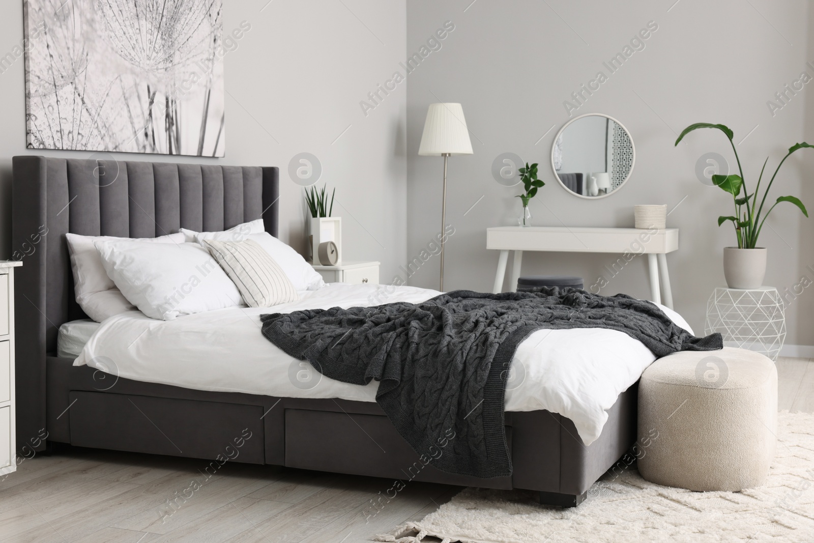 Photo of Stylish bedroom interior with large comfortable bed and dressing table