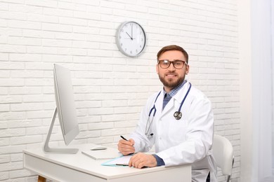 Photo of Portrait of pediatrician at table in clinic