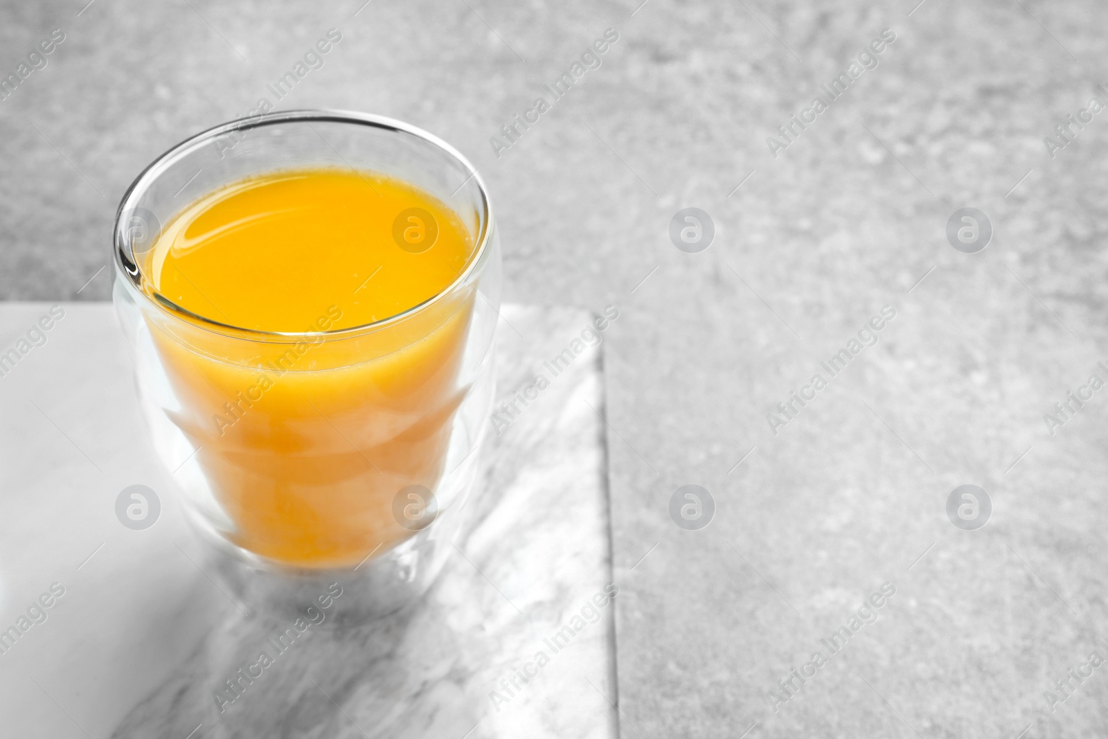 Photo of Glass of orange juice on table