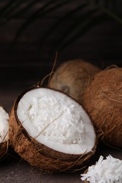 Coconut flakes in nut shell on brown table