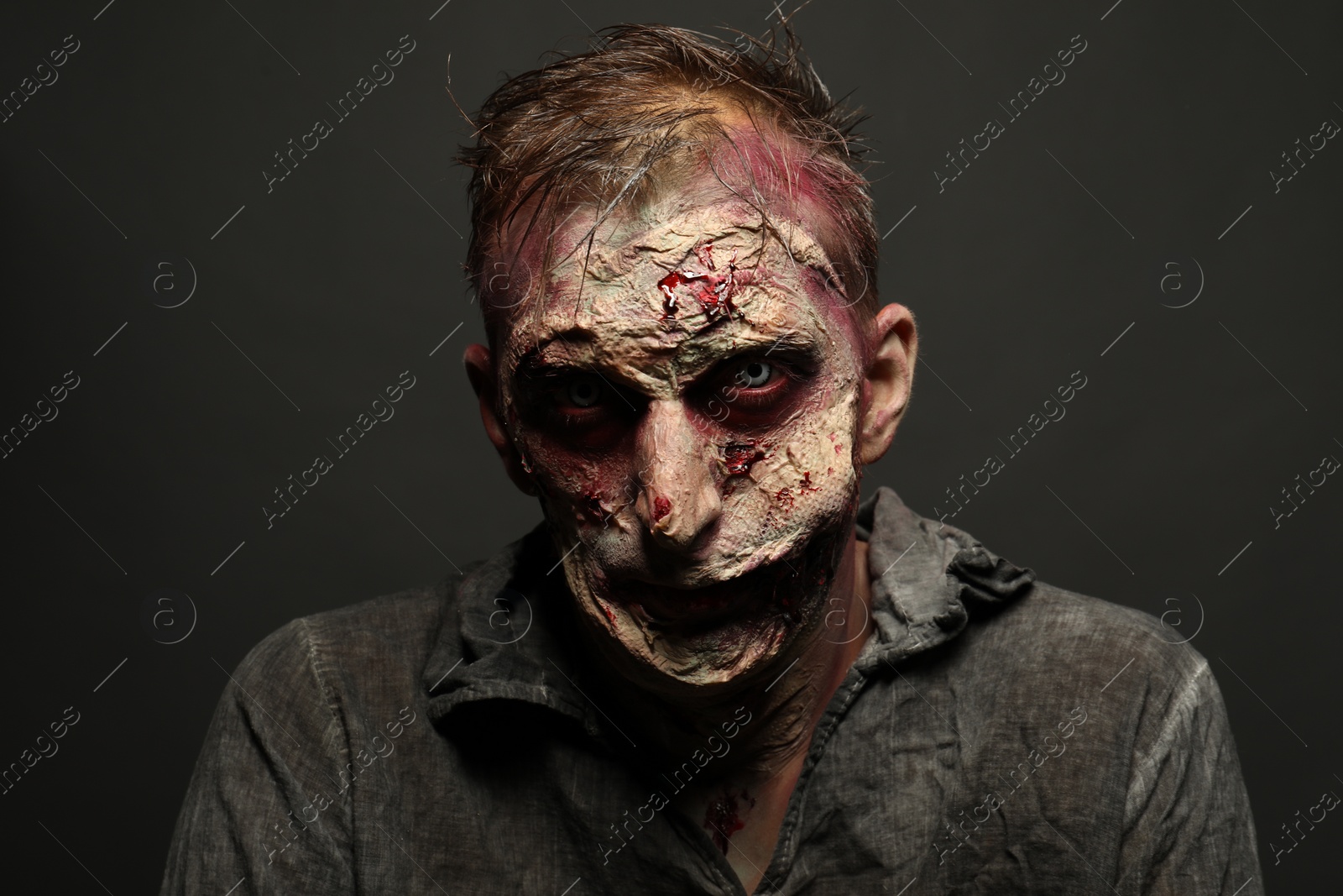 Photo of Scary zombie on dark background. Halloween monster