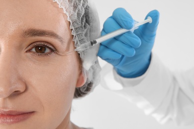 Photo of Woman getting facial injection on white background, closeup. Cosmetic surgery concept