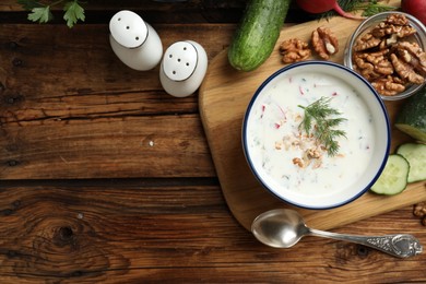 Photo of Delicious cold summer soup on wooden table, flat lay. Space for text