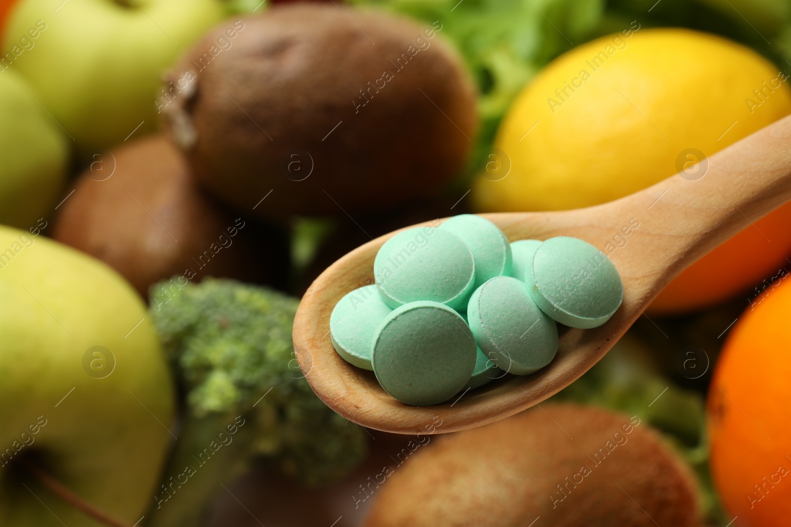 Photo of Dietary supplements. Spoon with pills over food products, closeup. Space for text