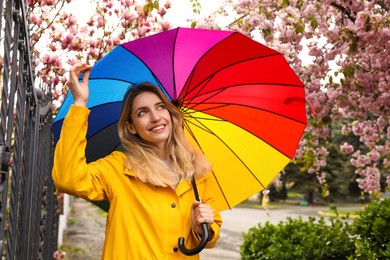Photo of Young woman with umbrella in park on spring day