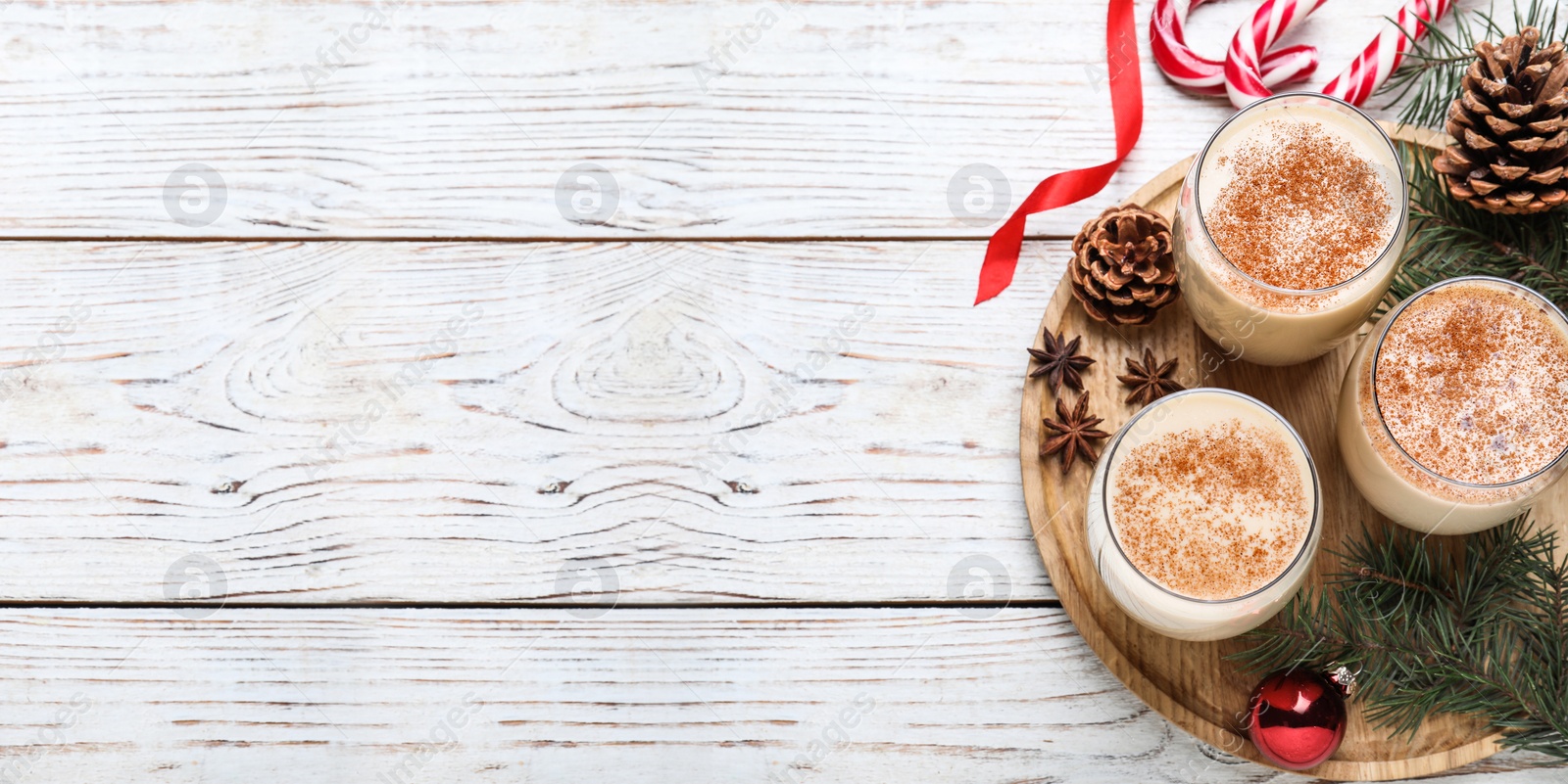 Image of Delicious Christmas cocktail with liqueur on white wooden table, flat lay with space for text. Banner design