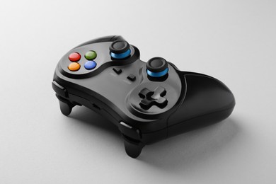 Photo of Black wireless game controller on light grey background