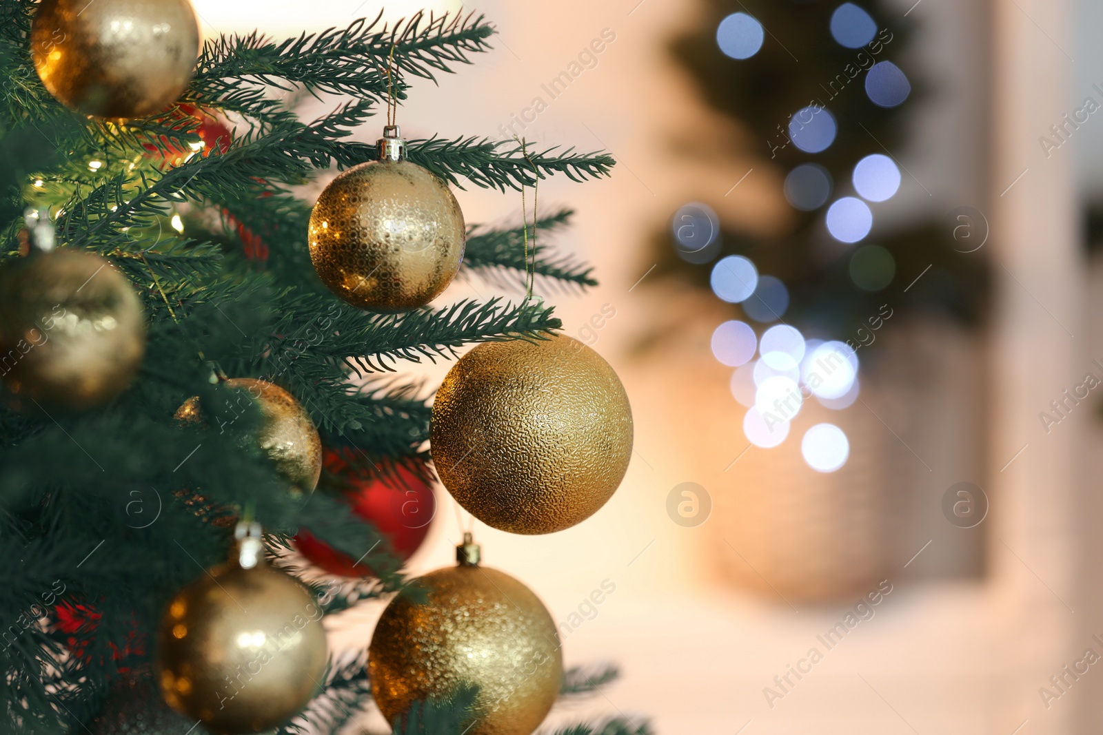 Photo of Christmas tree decorated with festive balls on light background, closeup. Space for text