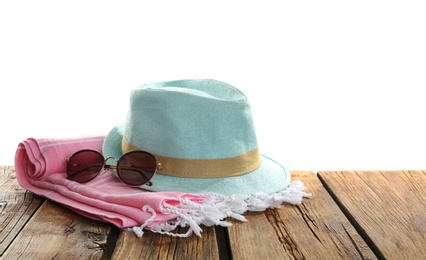Photo of Hat, sunglasses and blanket on wooden table. Beach accessories