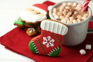 Photo of Tasty homemade Christmas cookie and hot chocolate with marshmallows on white wooden table, closeup