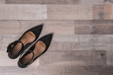 Photo of Pair of female shoes on wooden background, top view