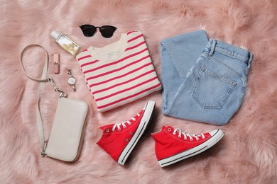 Photo of Pair of stylish red shoes, accessories and clothes on faux fur rug, flat lay