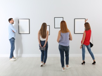 Photo of People viewing exposition in modern art gallery