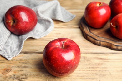 Photo of Ripe juicy red apples on wooden table