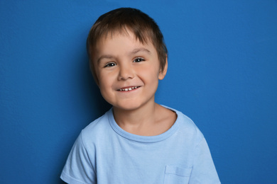 Photo of Portrait of happy little boy on blue background