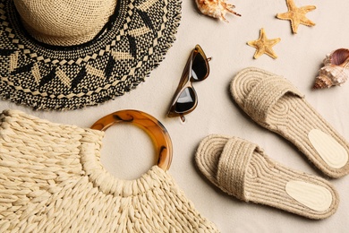 Different beach accessories on sand, flat lay