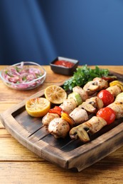 Photo of Delicious shish kebabs with grilled vegetables served on wooden table