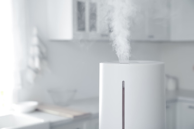 Photo of Modern air humidifier in kitchen, closeup. Space for text