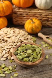 Photo of Many fresh pumpkins and seeds on wooden table