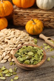 Photo of Many fresh pumpkins and seeds on wooden table