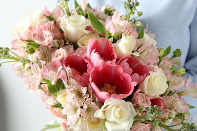 Photo of Woman with beautiful bouquet of fresh flowers on light background, closeup