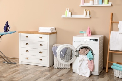 Photo of Bathroom interior with dirty towels in washing machine