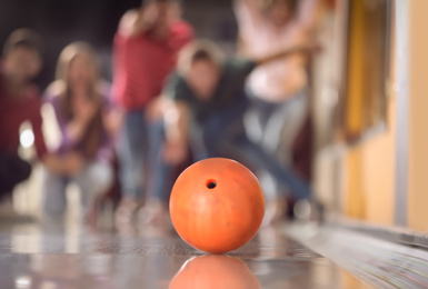 Photo of Group of friends in bowling club, focus on ball