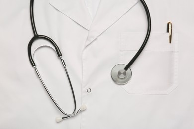 Photo of Stethoscope on white medical uniform, top view