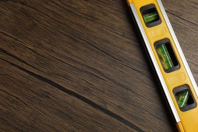 Photo of Building level on wooden table, top view. Space for text