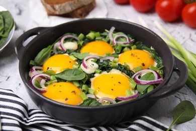 Photo of Tasty green Shakshouka served on white textured table, closeup