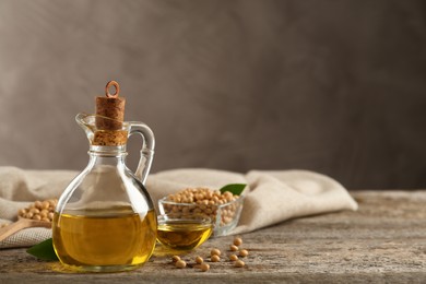 Photo of Composition with soybean oil on wooden table. Space for text