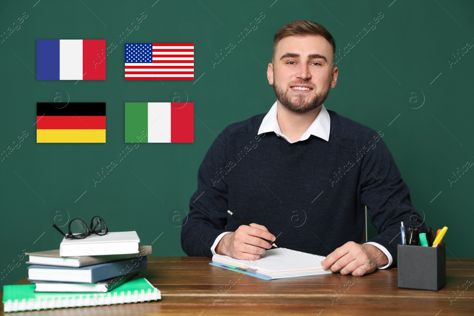 Image of Portrait of foreign languages teacher at wooden table and different flags green chalkboard