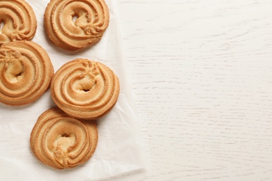 Photo of Danish butter cookies on wooden table, top view. Space for text