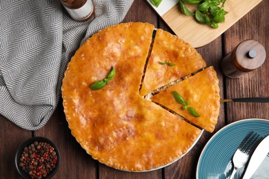 Photo of Delicious meat pie served on wooden table, flat lay