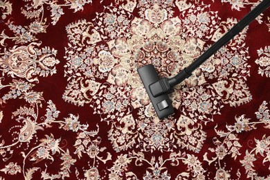 Photo of Hoovering carpet with vacuum cleaner, top view. Space for text