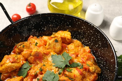 Photo of Delicious chicken curry in frying pan on table, closeup