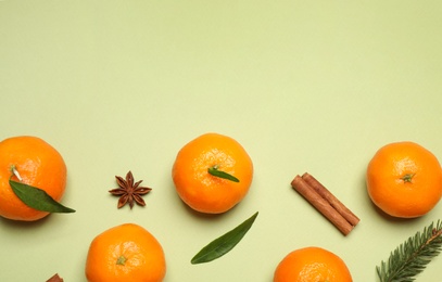 Christmas composition with tangerines on light green background, flat lay. Space for text