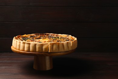 Photo of Delicious quiche with mushrooms on wooden table. Space for text