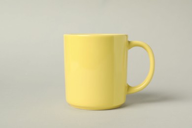 Photo of One yellow ceramic mug on light grey background