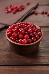 Photo of Fresh ripe cranberries in bowl on wooden table