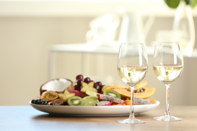 Photo of Delicious exotic fruits and wine on wooden table