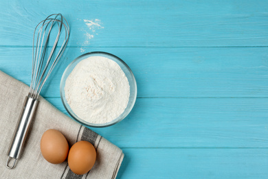 Photo of Flat lay composition with raw eggs on light blue wooden table, space for text. Baking pie